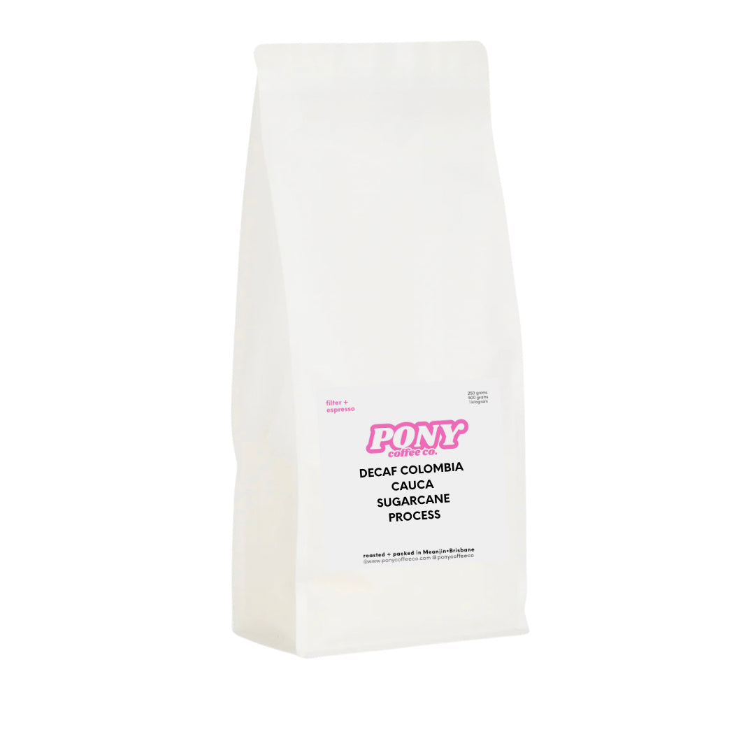 White coffee bag with pink and black text decaf coffee on a white background
